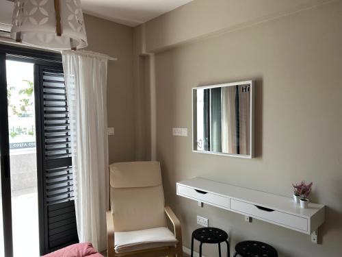 a bedroom with a desk and a mirror and a chair at Semeli The 3As Armonia, Ariadne, Artemis in Paphos City