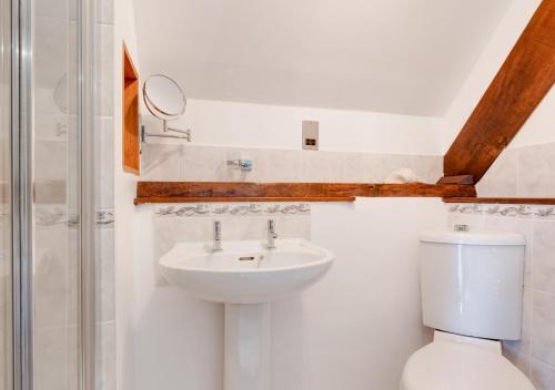 a bathroom with a sink and a toilet and a shower at Meadowside Barn in Meshaw