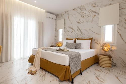 1 dormitorio con 1 cama grande y pared de piedra en Ktima Lino, en Agia Anna de Naxos