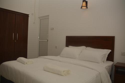 a bedroom with a bed with two towels on it at Leon Hilltop Resort in Kitulgala