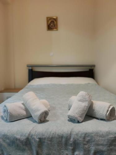 Una cama con dos toallas enrolladas encima. en Pegasus cosy house, en Atenas