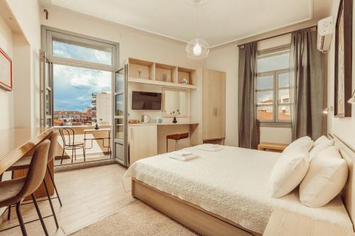 um quarto de hotel com uma cama e uma grande janela em Suitas em Atenas