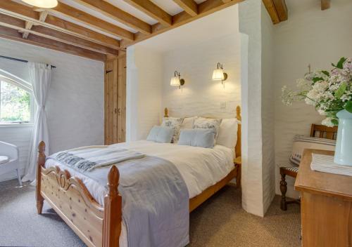 sypialnia z dużym łóżkiem i oknem w obiekcie Mole Cottage w mieście Parracombe