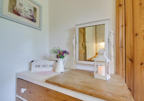 a dressing table with a mirror and flowers on it at Mole Cottage in Parracombe