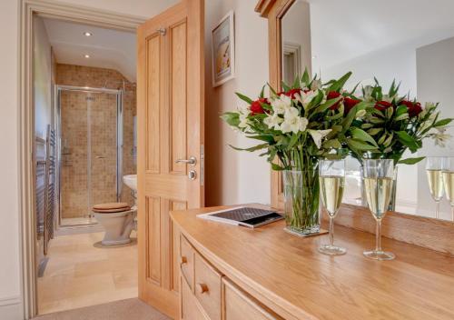 a bathroom with a vase of flowers on a counter at Northcote Lodge in Burrington