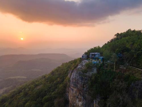 a train on the edge of a mountain at sunset at Green Acres Leisure Resort & Spa in Kandy