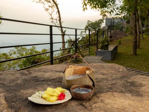 a plate of food on a table with a bowl of food at Green Acres Leisure Resort & Spa in Kandy