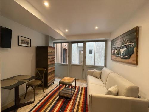 un salon avec un canapé et une table dans l'établissement Le St Louis 2 Joli Studio sur cour, à La Rochelle