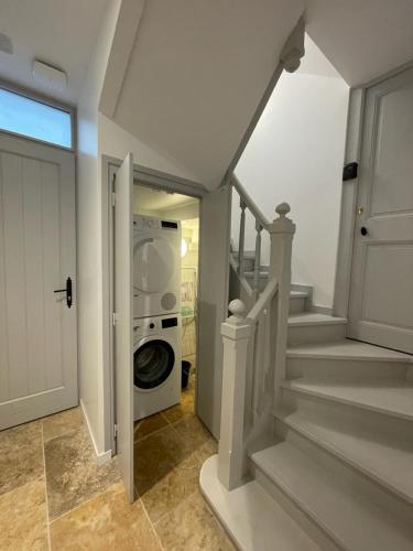 - un lave-linge et un sèche-linge dans le couloir d'une maison dans l'établissement Le St Louis 2 Joli Studio sur cour, à La Rochelle