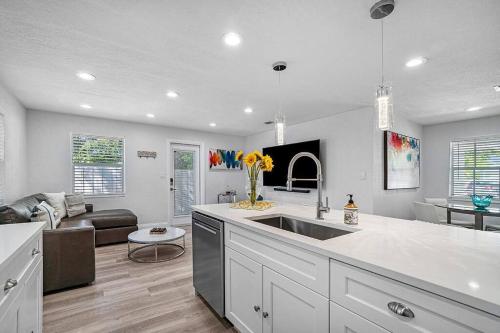 a kitchen with a sink and a living room at Casita Delray in Delray Beach