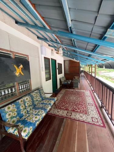 a room with a couch and a rug on a balcony at MyDusun Chalet, Taiping, Perak, Malaysia in Taiping
