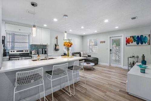 a kitchen and living room with a counter and chairs at Casita Delray in Delray Beach