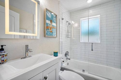 a bathroom with a sink and a tub and a toilet at Casita Delray in Delray Beach