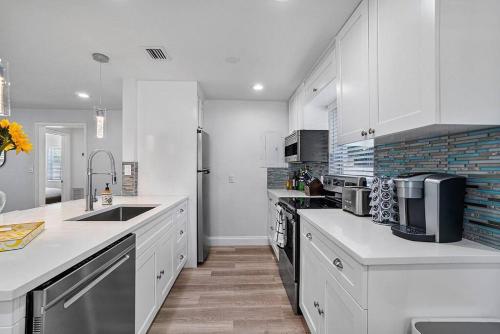 a kitchen with white cabinets and a counter top at Casita Delray in Delray Beach