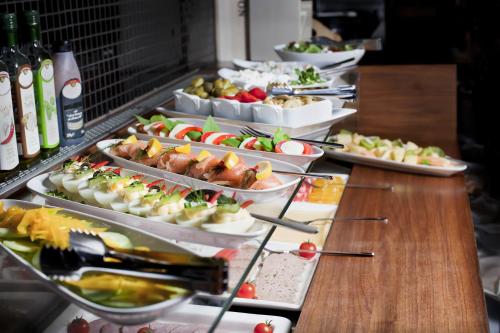 a buffet line with many plates of food and drinks at Bayjonn Boutique Hotel in Sopot