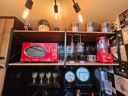 a shelf with a red toaster and glasses on it at Studio Aisiki - Apartamento em Brasília in Brasilia