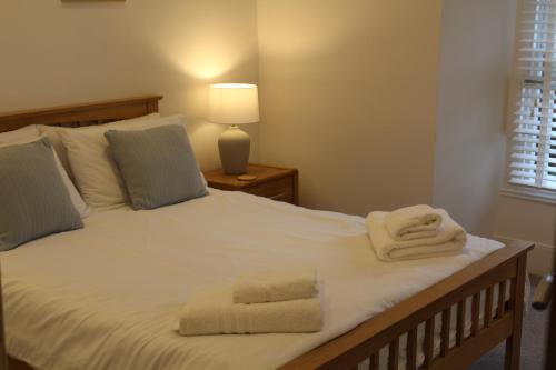 a bedroom with a large white bed with towels on it at Kidsty Pike in Bowness-on-Windermere