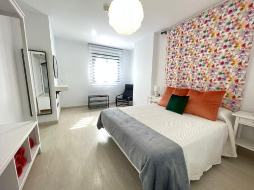 a bedroom with a large bed with a colorful wall at LHOME CÁDIZ in Cádiz