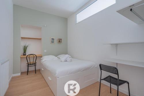 une chambre blanche avec un lit et une chaise dans l'établissement R'Apparts T3 Cozy Little Nest, à Grenoble