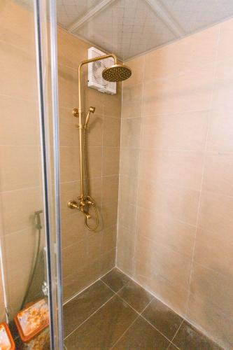a shower with a glass door in a bathroom at Bac Ha Lodge Retreat in Bắc Hà