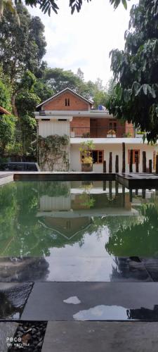 a house with a pond in front of it at the motville in Pulpally