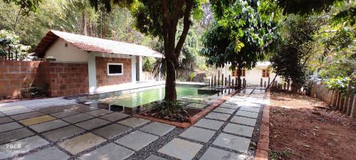 a swimming pool next to a house with a tree at the motville in Pulpally