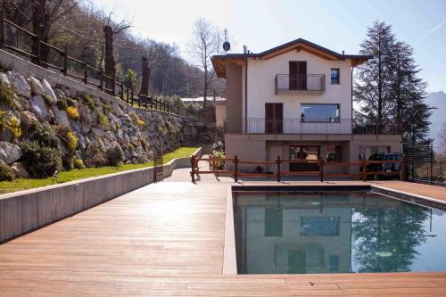 a house with a swimming pool in front of a house at Garni Le Grigne in Barzio