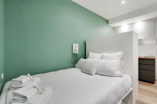 une chambre avec un lit blanc avec des serviettes dessus dans l'établissement Pick A Flat's Apartment near Eiffel Tower - Allée Marguerite Yourcenar, à Paris