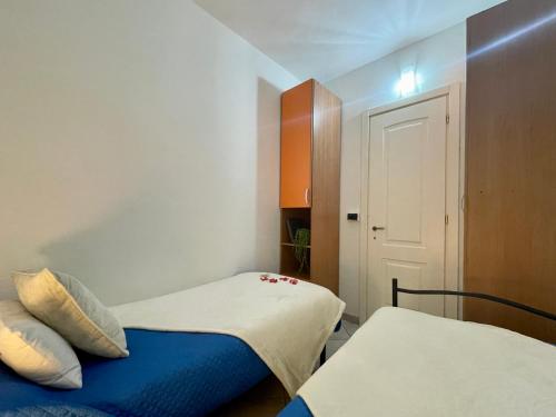 a small room with two beds and a door at La tua Vacanza al Mare in Borghetto Santo Spirito