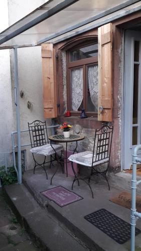 d'une terrasse avec 2 chaises, une table et une fenêtre. dans l'établissement La bruche, à La Broque