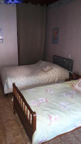 - 2 lits dans une chambre ornée de fleurs sur les draps dans l'établissement La bruche, à La Broque