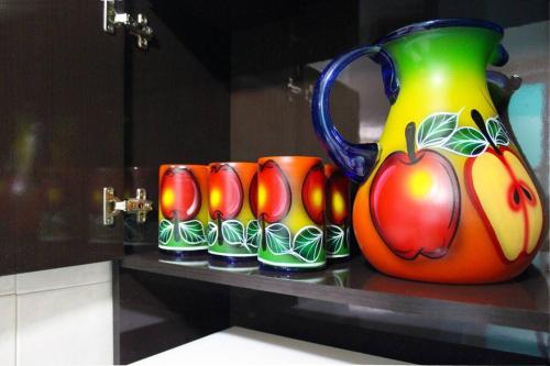 a group of cups and a large vase on a counter at Colorida Casa Azul en Texcoco Centro WiFi Cocina in Texcoco de Mora