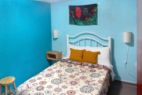 Dormitorio azul con cama y pared azul en Colorida Casa Azul en Texcoco Centro WiFi Cocina, en Texcoco de Mora