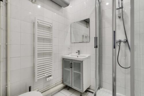 une salle de bain blanche avec une douche et un lavabo dans l'établissement Pick A Flat's Apartment near Eiffel Tower - Allée Marguerite Yourcenar, à Paris