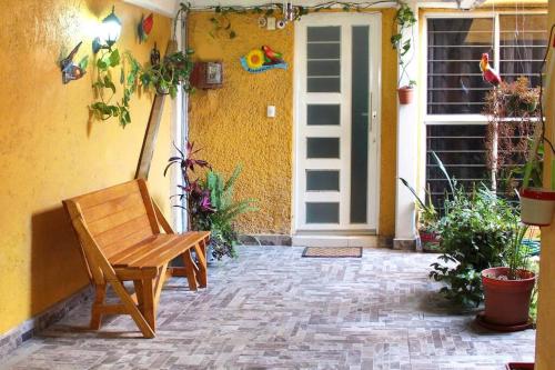 a wooden bench sitting in front of a house at Colorida Casa Azul en Texcoco Centro WiFi Cocina in Texcoco de Mora