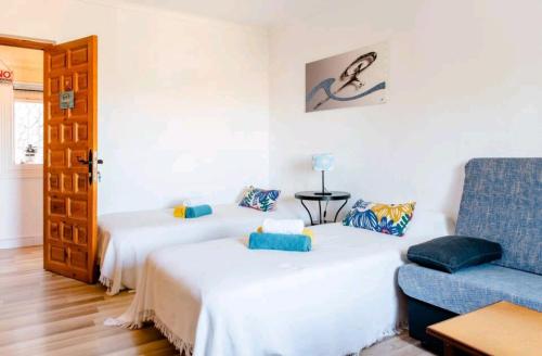 una camera con due letti e un divano blu di Casa Ridao-Habitación Indalo con vistas a Mojácar