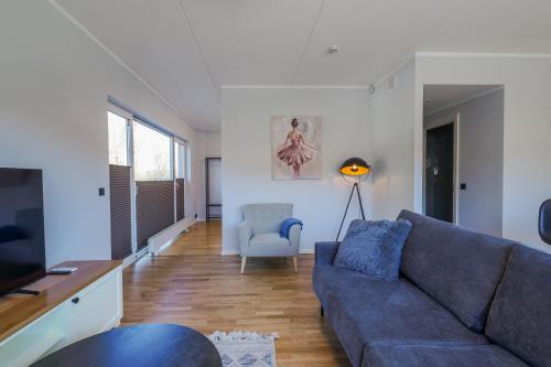 a living room with a blue couch and a chair at Tähe Apartment in Tartu