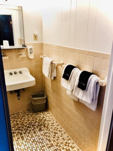 a bathroom with a sink and a toilet and towels at Lankford Hotel and Lodge in Ocean City