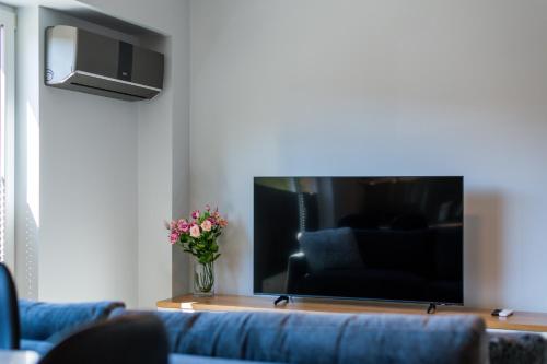 a living room with a blue couch and a vase of flowers at Tähe Apartment in Tartu