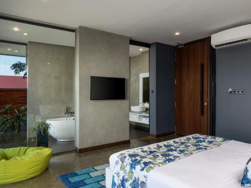 a bedroom with a bed and a tub and a television at Green Acres Leisure Resort & Spa in Kandy