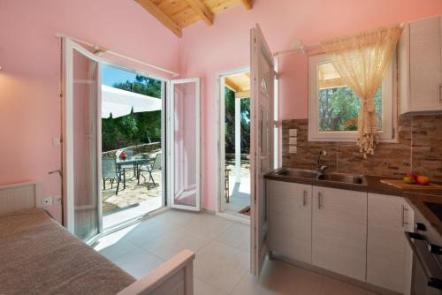 eine Küche mit einem Waschbecken und eine Tür zu einer Terrasse in der Unterkunft Kabos house in Mastorátika