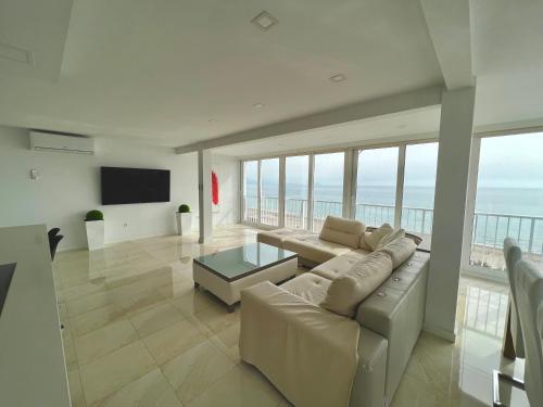 een woonkamer met een bank en uitzicht op de oceaan bij Texas in Alicante
