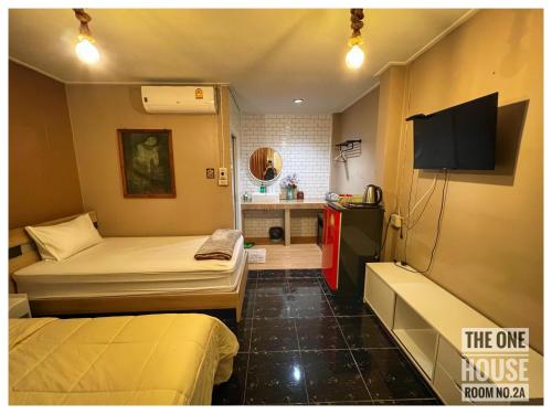 a small room with two beds and a tv at The One House in Nan