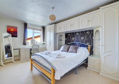 a bedroom with a large bed with white cabinets at Summer Breeze in Northam