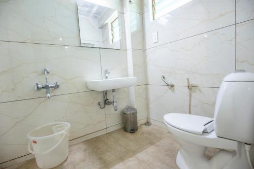 ein Bad mit einem WC und einem Waschbecken in der Unterkunft Hotel Jc Grand in Kodaikanal