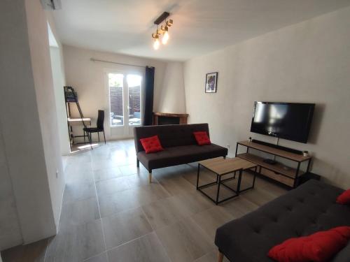 un salon avec un canapé et une télévision à écran plat dans l'établissement La Villa Beata, à Orange