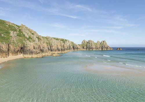 a view of a beach with rocks in the water at The Granary in Porthcurno