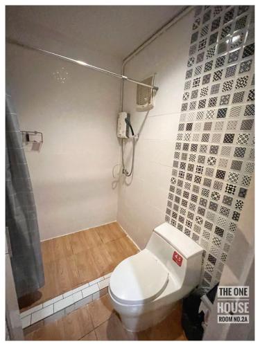 a bathroom with a white toilet and a shower at The One House in Nan