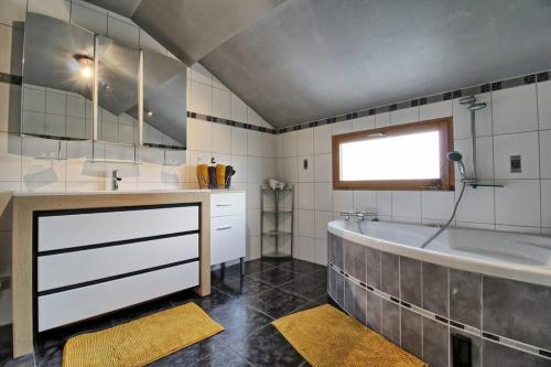 uma casa de banho com uma banheira e um lavatório em Maison Le Vignoble avec jardin - 6 personnes em Ribeauvillé