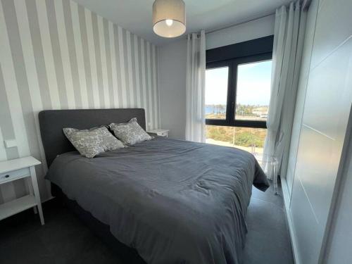 um quarto com uma cama e uma janela em New built 3-bed penthouse with pool, Mar de Plata em Mazarrón